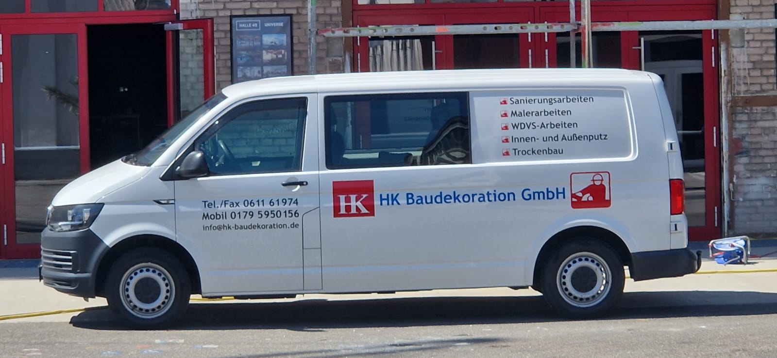 Firmenfahrzeug der HK Baudekoration GmbH vor einer Baustelle